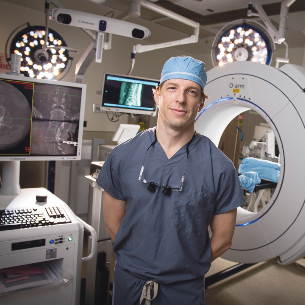 Chad Patton, MD, medical director of The Spine Center at AAMC, is shown in front of the new O-arm 3-D imaging system.