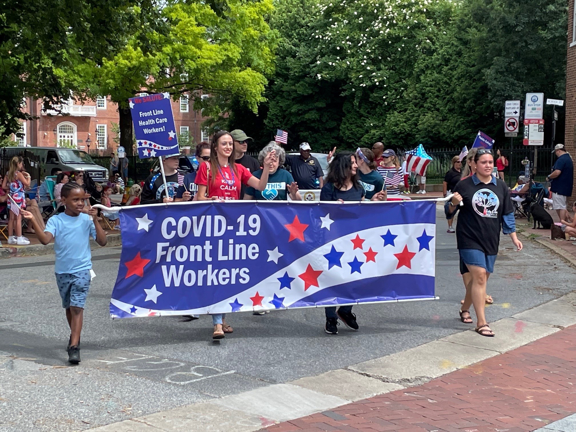 A group from LHAAMC marching in the parade behind a banner
