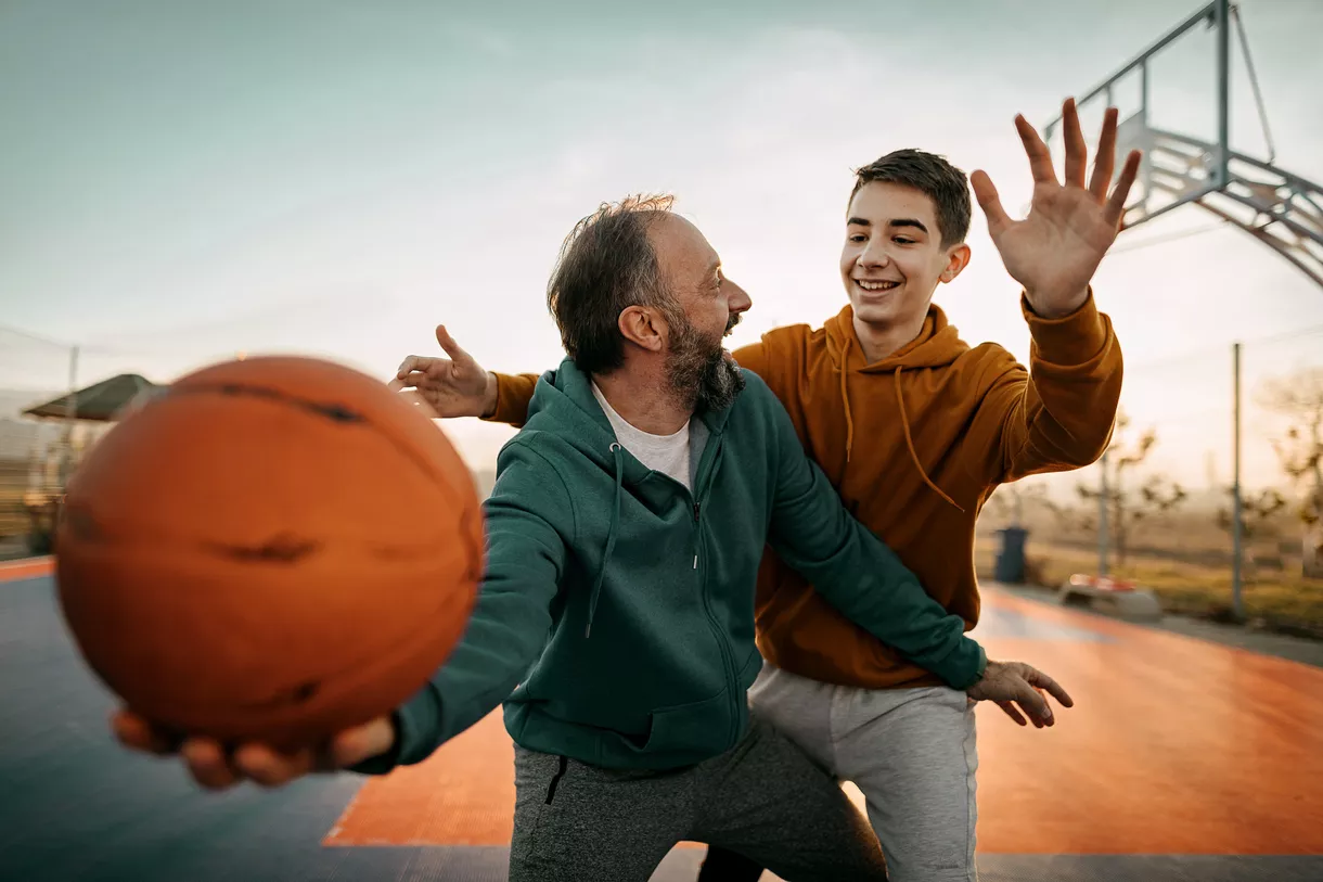father and son playing basketball