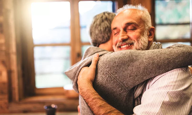 Senior hugging younger person