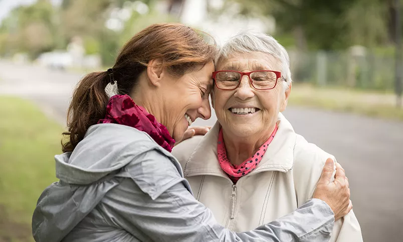 Woman hugging senior nature trail
