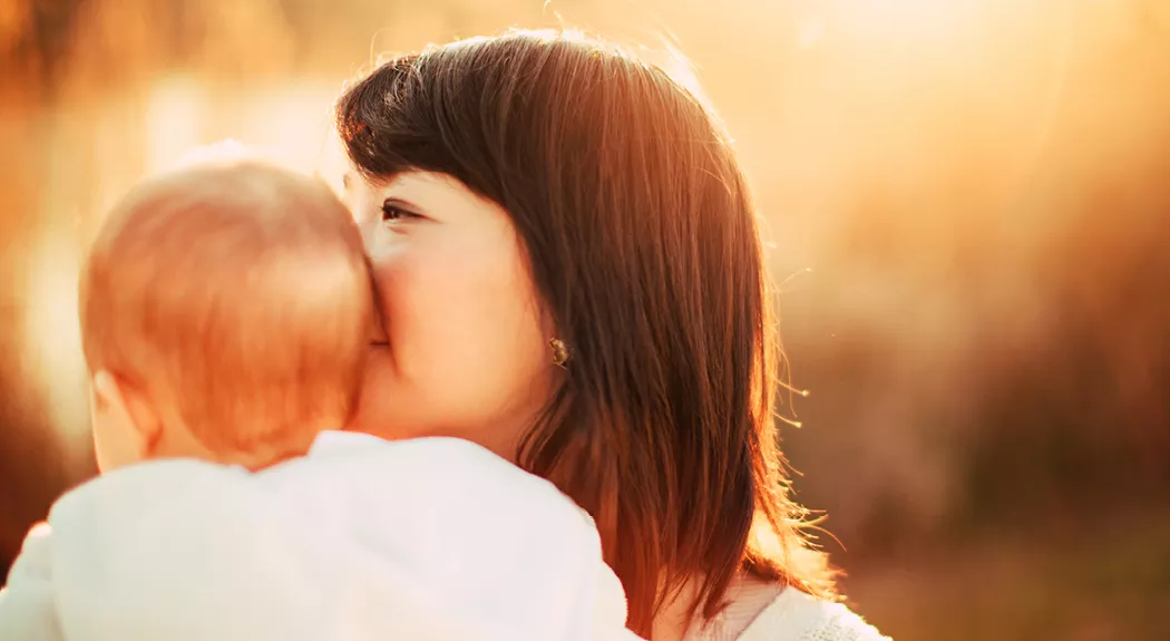 Mother kissing her baby