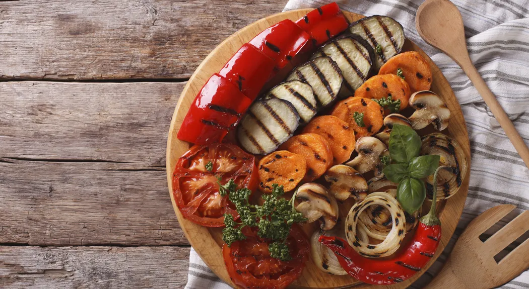 Grilled vegetables on a chopping board horizontal top view
