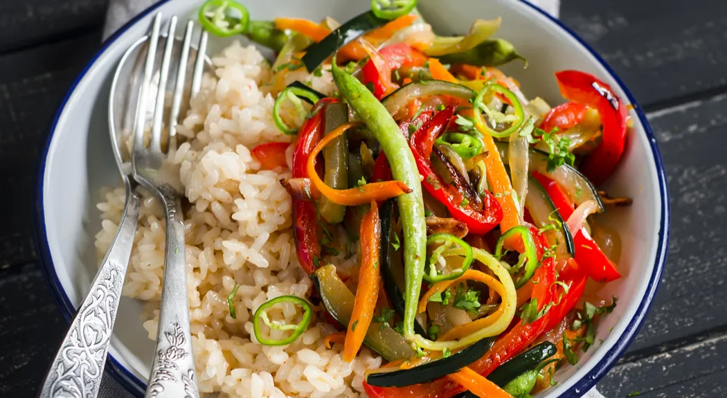 rice with vegetable stir-fry on white enamel dish